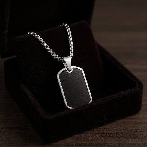 Eleganter Stahlanhänger in Silber-Schwarz mit glatter Oberfläche für Gravuren, präsentiert in edler Geschenkbox als stilvolles Präsent für Männer.