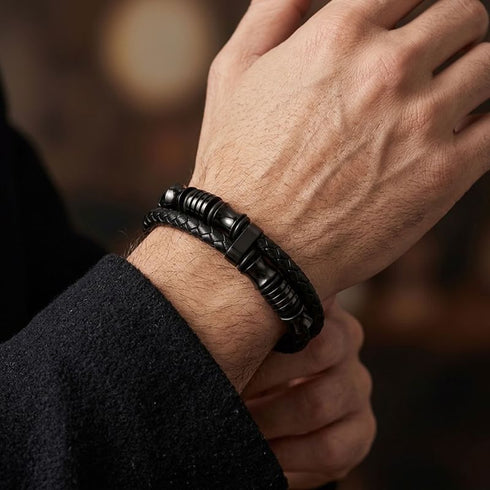 UNIQAL DOUBLE LAYER BLACK am Handgelenk – Nahaufnahme der geflochtenen Lederstränge und gerillten Edelstahl-Elemente.