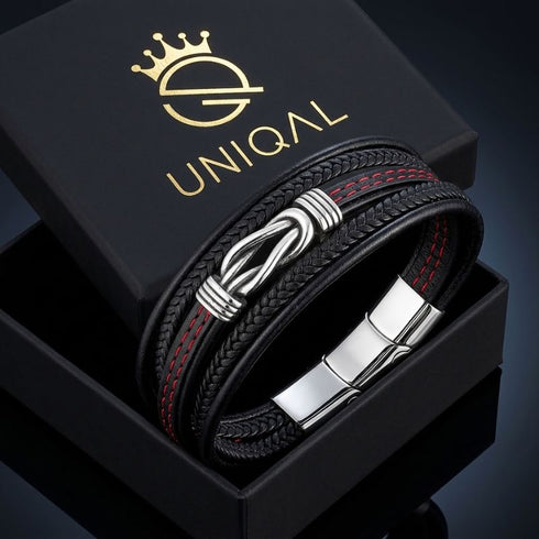 ENDLOS Infinity-Armband von UNIQAL in einer geöffneten schwarzen Geschenkbox mit goldfarbenem Logo, roten Nähten und silberfarbenen Edelstahlelementen.