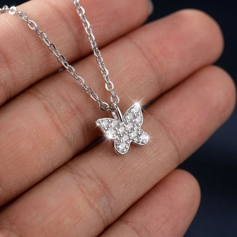FARFALLA Silberkette von UNIQAL auf einer Hand, mit glitzernden Moissaniten auf den filigranen Schmetterlingsflügeln.