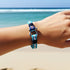 Uniqal FLUNDER maritimes Armband in türkisblauer Farbgebung am Handgelenk getragen inspiriert von Küste und Freiheit