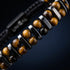 Detailaufnahme eines hochwertigen Natursteinarmbands mit goldenem Tigerauge und dunkel poliertem Edelstahl