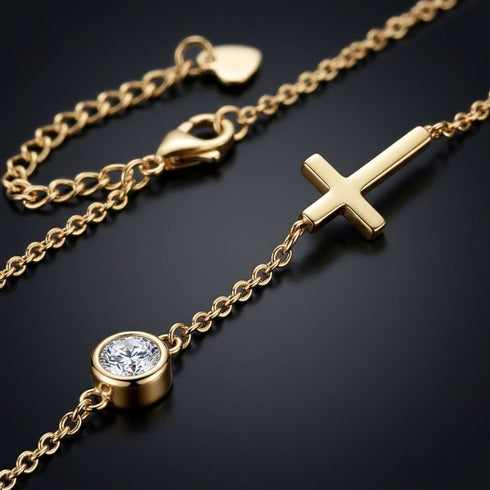 UNIQAL GRACE 14K GOLD Moissanit-Armband mit sichtbarem Karabiner, Verlängerungskette und Herzplättchen neben den goldfarbenen Designelementen.
