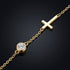 Makrodetail des UNIQAL GRACE 14K GOLD Moissanit-Armbands mit rundem Stein in Zargenfassung und poliertem Kreuzmotiv auf dunkler Oberfläche.