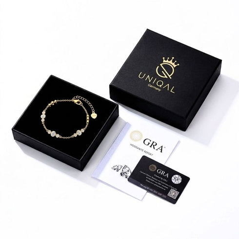 UNIQAL GRAZIA 14K GOLD Moissanit-Armband in einer geöffneten Schmuckbox neben passendem Deckel, GRA-Bericht und Zertifikatskarte