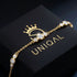 GRAZIA 14K GOLD Moissanit-Armband von UNIQAL diagonal auf einer schwarzen Markenbox, mit feinen Kettengliedern und goldenen Lichtreflexen.