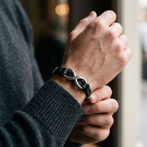Uniqal INFINITY SILVER Armband am Handgelenk – schwarzes Herrenarmband mit silberfarbenem Unendlichkeits-Symbol für einen modernen Casual-Look.