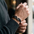 Uniqal INFINITY SILVER Armband am Handgelenk – schwarzes Herrenarmband mit silberfarbenem Unendlichkeits-Symbol für einen modernen Casual-Look.