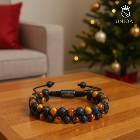 Zweireihiges Lava- und Tigerauge-Armband von Uniqal auf Holztisch, natürliches Herrenarmband im warmen Licht.