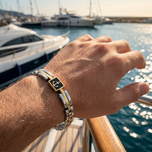 UNIQAL MARINO maritimes Edelstahl Armband am Handgelenk vor einer Yacht – elegantes Anker Armband mit Hämatit in Silber, Gold und Anthrazit