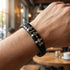 Lederarmband am Handgelenk getragen mit gravierbaren Edelstahlringen für Namen Symbole und persönliche Botschaften