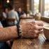 Schwarzes Lederarmband im Alltag getragen im Café mit stilvollem Look und individuell gravierbaren Details