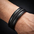 Uniqal MULTY LAYER Herrenarmband am Handgelenk – schwarzes mehrreihiges Lederarmband mit geflochtenem Mittelteil und modernem Design.