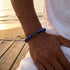 Hochwertiges Lapislazuli Schmuckarmband mit schwarzem Kreuz am Handgelenk für einen modernen und eleganten Look