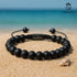 Schwarzes Onyx Armband aus matten Steinen im Sand am Meer – stilvolles Accessoire für Sommer, Reisen und Urlaub uniqal