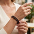 Uniqal PASSION RED TIGER EYE Armband am Handgelenk – schwarz-rotes Schmuckarmband mit Tigerauge-Perlen und geflochtenem Leder für einen modernen Casual-Look