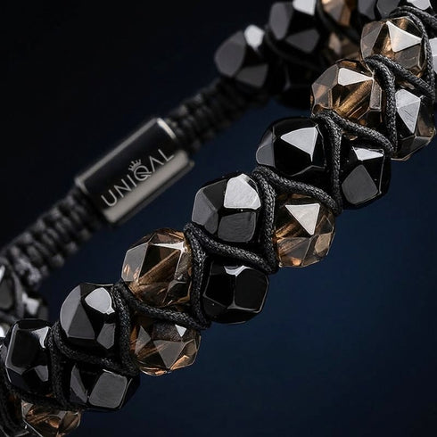 Makroaufnahme eines Natursteinarmbands mit Rauchquarz und schwarzem Turmalin, facettierte Edelsteine mit tiefen dunklen Reflexionen