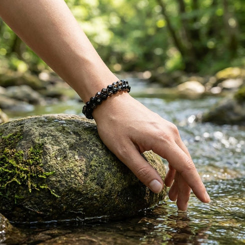 Natursteinarmband aus Rauchquarz und schwarzem Turmalin am Handgelenk in natürlicher Umgebung getragen
