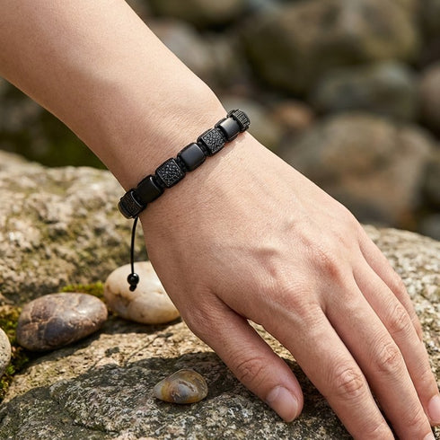 Edelsteinarmband aus schwarzem Achat am Handgelenk getragen in natürlicher Umgebung mit ruhiger eleganter Ausstrahlung