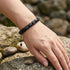 Edelsteinarmband aus schwarzem Achat am Handgelenk getragen in natürlicher Umgebung mit ruhiger eleganter Ausstrahlung