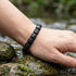 Modernes Natursteinarmband aus schwarzem Achat am Handgelenk getragen mit minimalistischer Struktur und Gravur Option