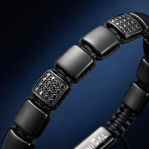Makroaufnahme eines Armbands aus schwarzem Achat mit geometrischen Steinsegmenten und gravierbarem Metallelement