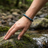 Blaues Tigerauge Armband am Handgelenk über Wasser getragen mit ruhiger Ausstrahlung und optionaler Gravur am Verschluss