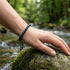 Edelsteinarmband aus blauem Tigerauge am Handgelenk getragen mit elegantem Lichtspiel und personalisierbarem Detail