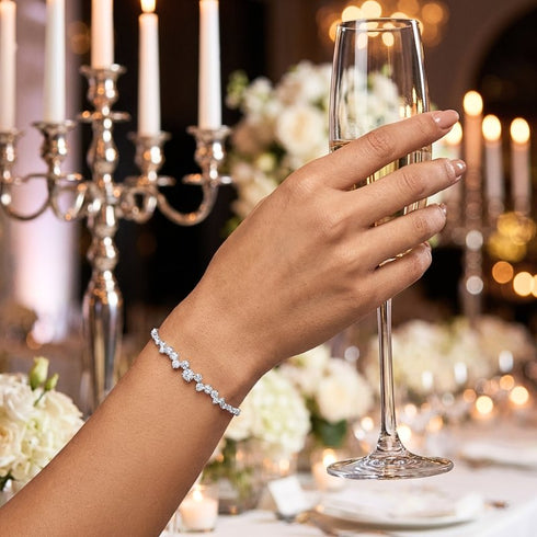 STELLARA Moissanit Schmuckarmband aus Sterling Silber beim Anstoßen mit Sektglas, funkelnder Armschmuck für elegante Events und luxuriöse Anlässe