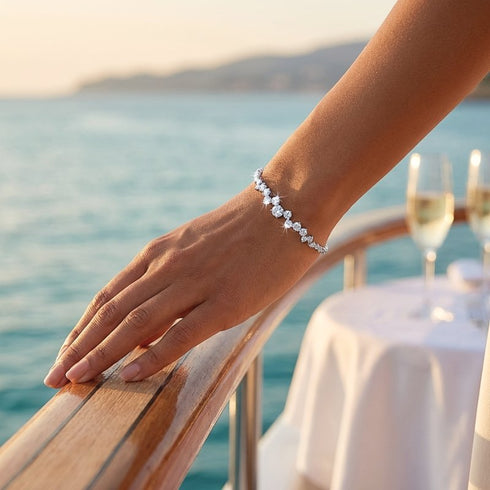 STELLARA feines Moissanit Damenarmband am Handgelenk vor Küstenpanorama auf Balkon mit Meerblick, eleganter Silberschmuck für stilvolle Sommerabende