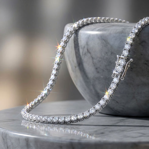 UNIQAL Tenniskette Moissanit 2 mm auf grauem Dekosockel, mit sichtbaren Steinfassungen und seitlichem Sicherheitsverschluss.