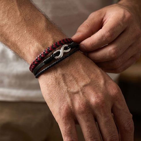 Eine Person richtet das uniqal timeless Armband mit rot-schwarzem Flechtband und silberfarbenem Unendlichkeitszeichen am Handgelenk.
