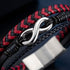 Silberfarbenes Unendlichkeitszeichen am uniqal timeless Armband zwischen einem rot-schwarzen Flechtband und einem schmalen dunklen Band.