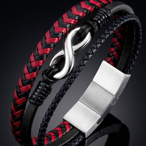 Nahaufnahme des uniqal timeless Armbands mit rot-schwarzen und dunklen Bändern, silberfarbenem Unendlichkeitszeichen und breitem Verschluss.