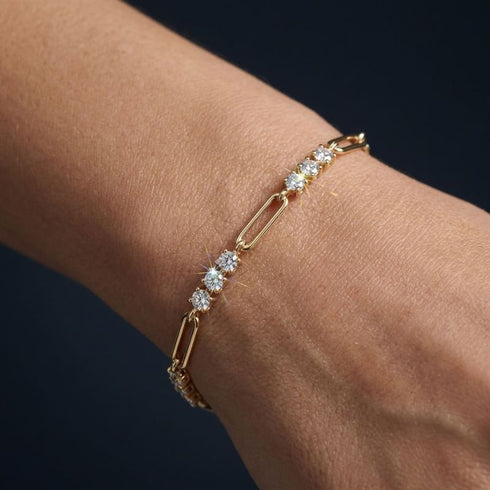 TRIA LINK 14K GOLD Moissanit-Armband von UNIQAL am Handgelenk, mit deutlich sichtbarem Wechsel aus Steingruppen und länglichen Gliedern.