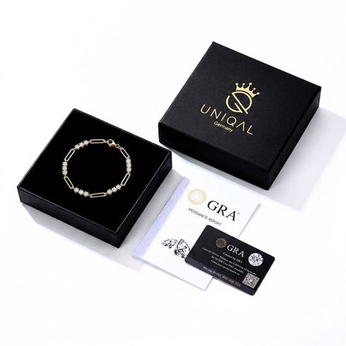 UNIQAL TRIA LINK 14K GOLD Moissanit-Armband in einer geöffneten schwarzen Schmuckbox neben Markendeckel und GRA-Unterlagen