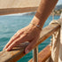 UNIQAL TRIA LINK 14K GOLD Moissanit-Armband am ausgestreckten Handgelenk, mit warmen Goldreflexen und funkelnden Steinen im Sonnenlicht.