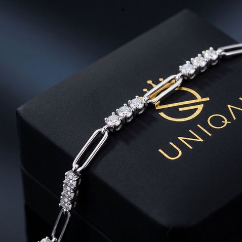 UNIQAL TRIA LINK Moissanit-Armband über einer schwarzen Markenbox, mit abwechselnden Silbergliedern und gefassten Steingruppen.