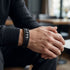 Uniqal VORTEX S Herrenarmband am Handgelenk – schwarzes Leder mit geflochtenen Elementen und silberfarbenen Akzenten für einen modernen Business-Casual-Look