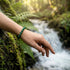 Uniqal Naturperlen in kräftigem Grün vor Wasser – optische Tiefe, zentrierender Charakter, elegante Präsenz