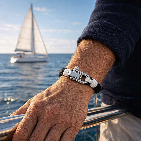 Elegantes Armband QUERENCIA in Schwarz Weiß getragen an Deck eines Segelboots mit ruhiger Meeresatmosphäre von Uniqal