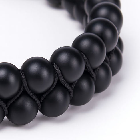 Nahaufnahme eines zweireihigen Onyx Armbands mit matten schwarzen Natursteinperlen, hochwertige Detailansicht von UNIQAL