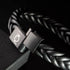 Detailaufnahme des geöffneten Magnetverschlusses am BLACK BRAID Lederarmband mit sichtbarem Verbindungsstift und UNIQAL-Symbol