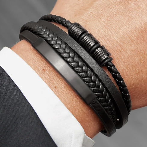 BLACK SHAPE getragen am Handgelenk kombiniert mit weiteren Armbändern – moderner Layering Stil mit geflochtenem Leder und Edelstahlakzenten
